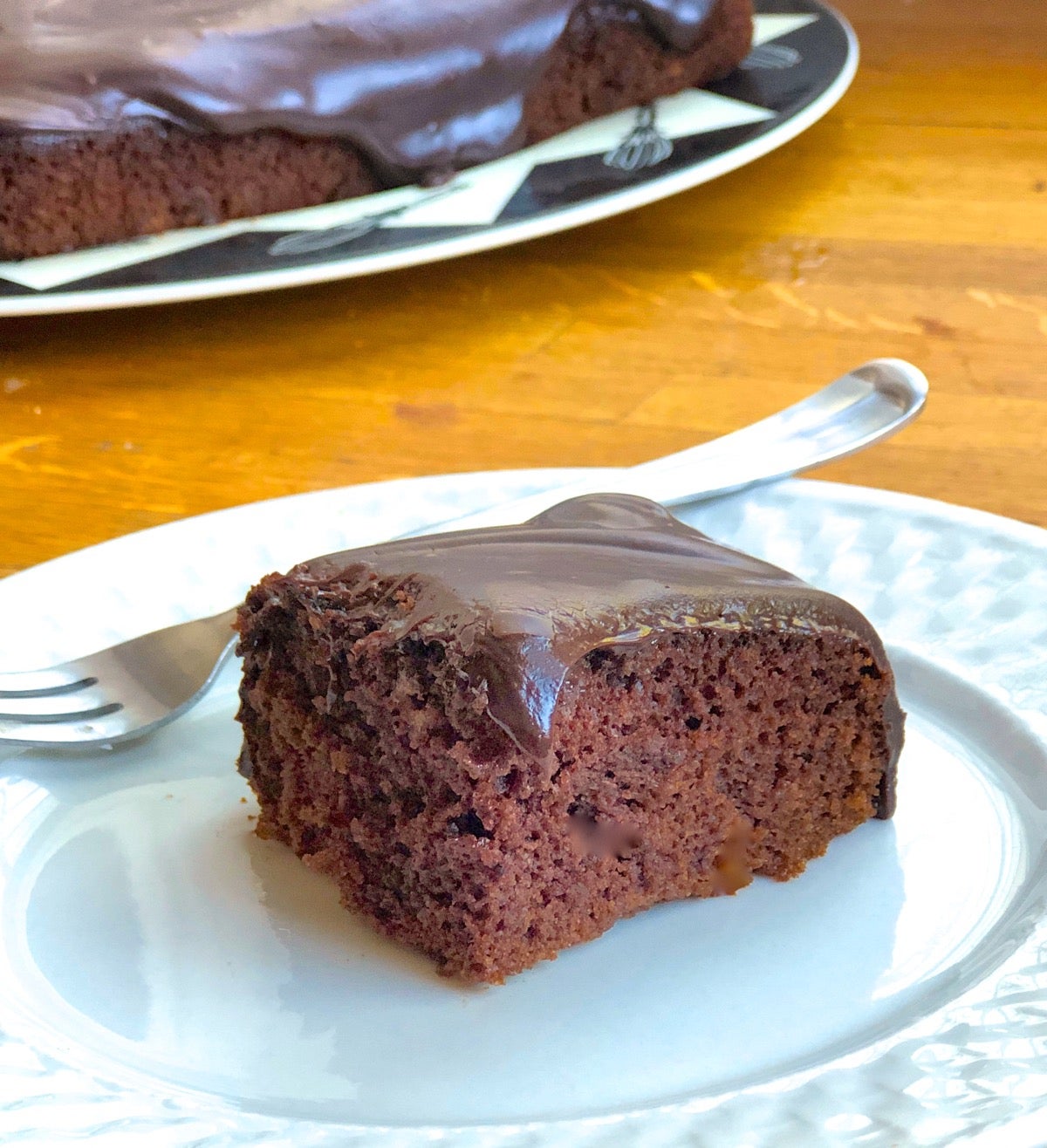 Square of frosted Chocolate Cake Pan Cake made with Baking Sugar Alternative on a plate.